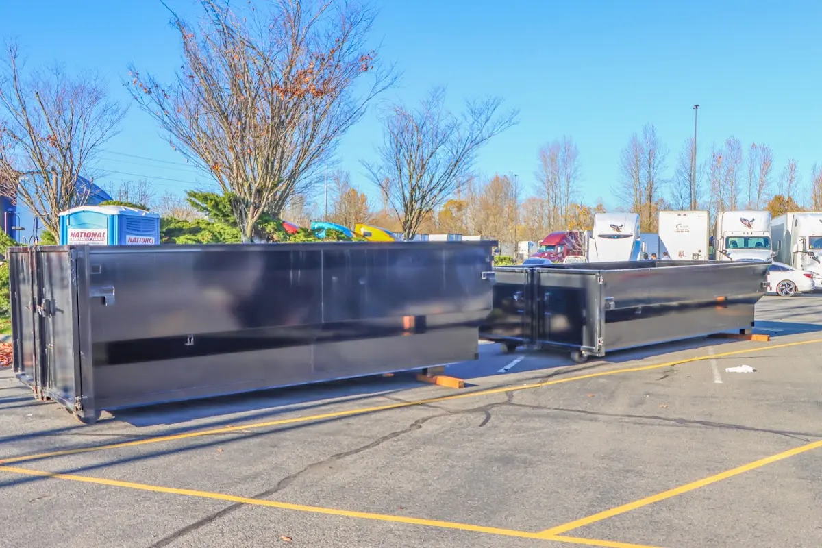 Professional dumpster rental service with roll-off container on residential driveway in Doffing